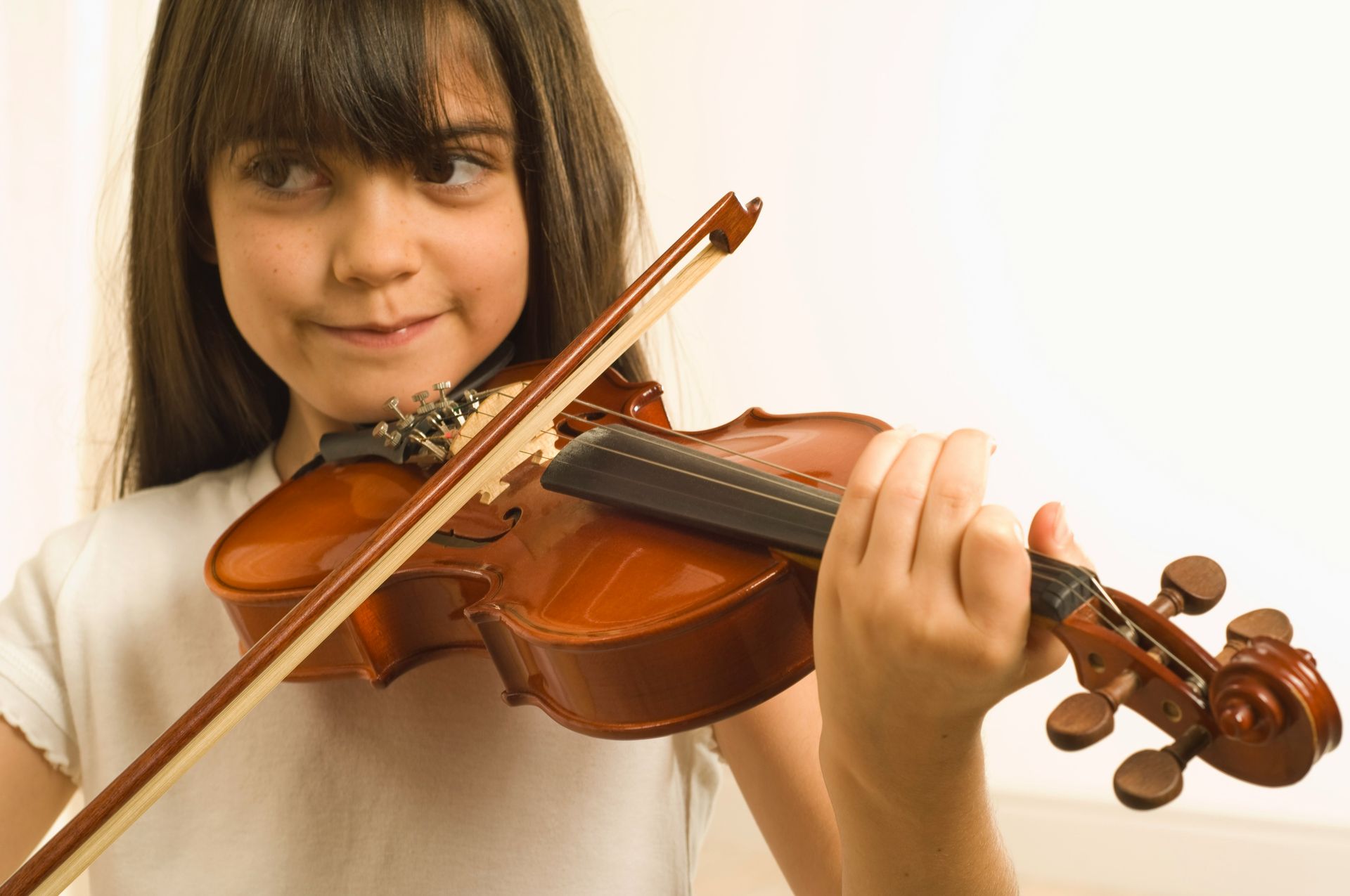 A young girl playing a violin
